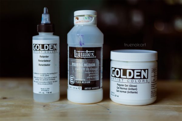 Two bottles and a jar of acrylic painting mediums.